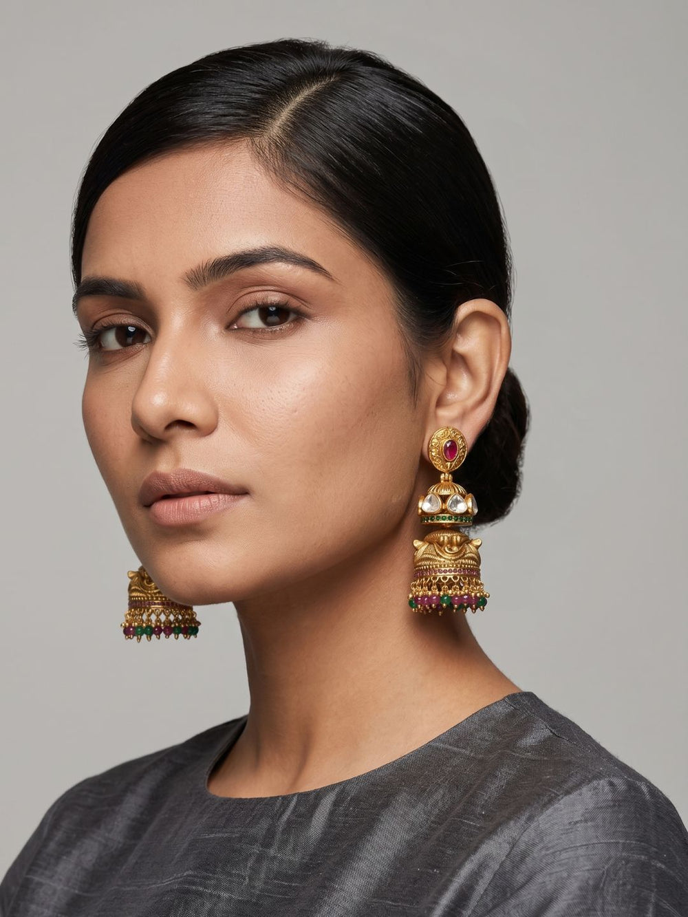 Gold plated antique Jhumka earrings with layered dome-shaped design, Kundan stones, colourful gemstone beads and detailed craftsmanship.