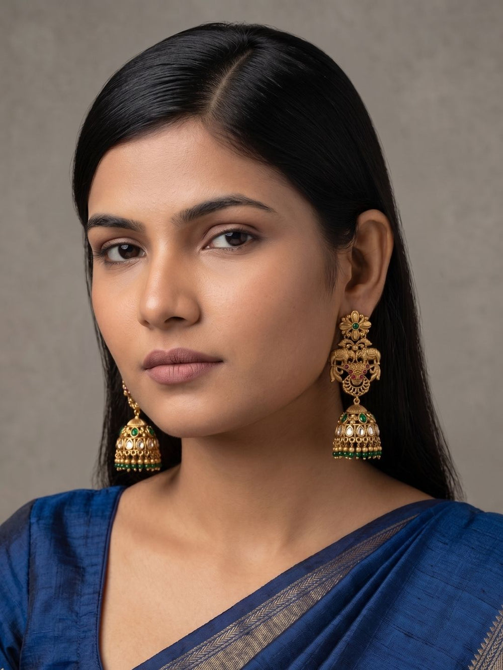 Antique gold temple jhumka earrings with symbolic elephant motifs, colourful green stones, floral stud and gold bead fringe