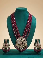 Antique-style necklace set featuring a prominent red centre stone, intricate peacock motifs, white Polki and CZ accents, red beads and pearl details.