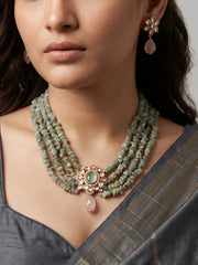 Layered pastel green aquamarine bead necklace with a Kundan floral pendant and matching pink-drop earrings styled with ethnic attire.