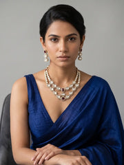 Double layer Polki necklace featuring ruby-coloured accents, symmetrical stonework and detailed gold-tone framing, styled for traditional wedding wear