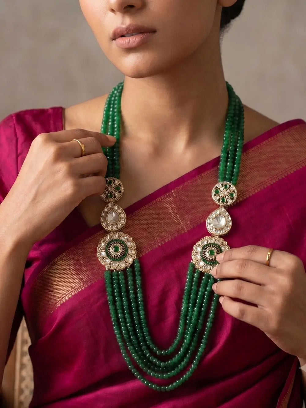 Emerald green layered necklace with natural jade beads, Kundan Polki floral brooches and gold-plated detailing for bridal and wedding styling.