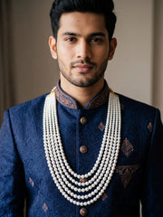 Traditional dulha mala featuring multiple strands of lustrous white shell pearls in graduated lengths, designed to complement men's sherwanis for weddings.