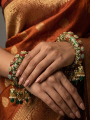 Gold plated green Meenakari kada bangle featuring Kundan-style stones, synthetic pearls and traditional floral detailing for bridal styling.