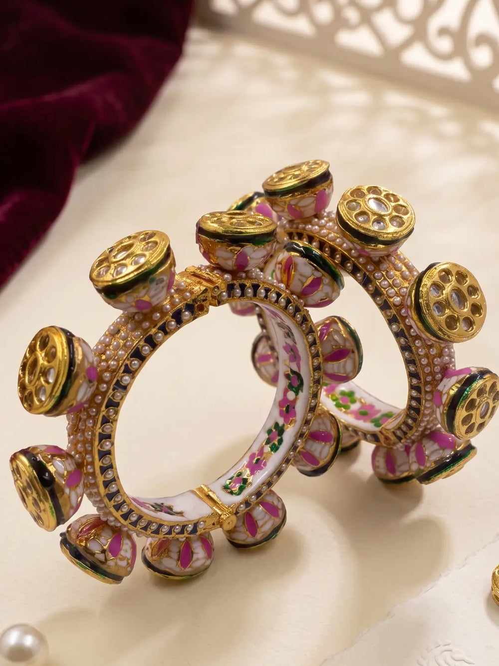 Gold plated green and pink Kundan Pacheli kada bangles with floral Meenakari, blue and white pearl detailing for sarees and lehengas.