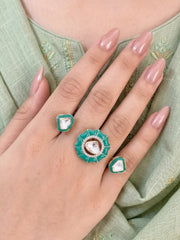 Mint green gold plated Kundan double finger ring with enamel and Polki stones, styled as a statement accessory for weddings and festive occasions.