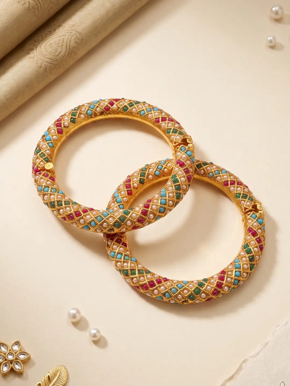 Gold plated multicolor Jadau bangles with closely placed stones and pearl accents, designed for bridal, wedding and festive jewellery styling.