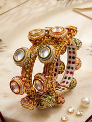 Gold plated multicolour Kundan Gokhru kada bangles with red and green Meenakari, pearl accents and ornate detailing for sarees and lehengas.