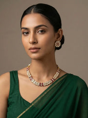 A women wearing Gold Plated Kundan Necklace And Earring Set wirh ruby stones on a green saree | Festive And Wedding Wear Jewellery