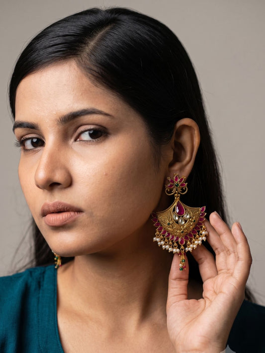 Golden pink gold plated Chandbali earrings with Kundan stones, pink ruby accents, floral detailing and pearl drops for bridal and festive looks.