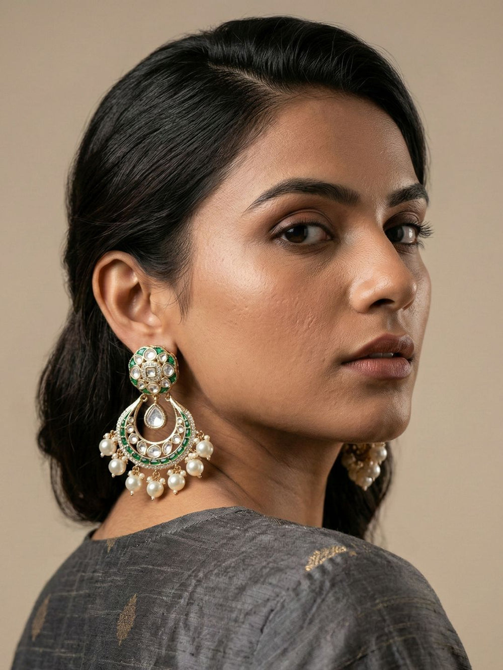 Green Kundan Chandbali earrings featuring a Polki centre, detailed stonework, emerald enamel accents and cascading pearl drops for festive wear.