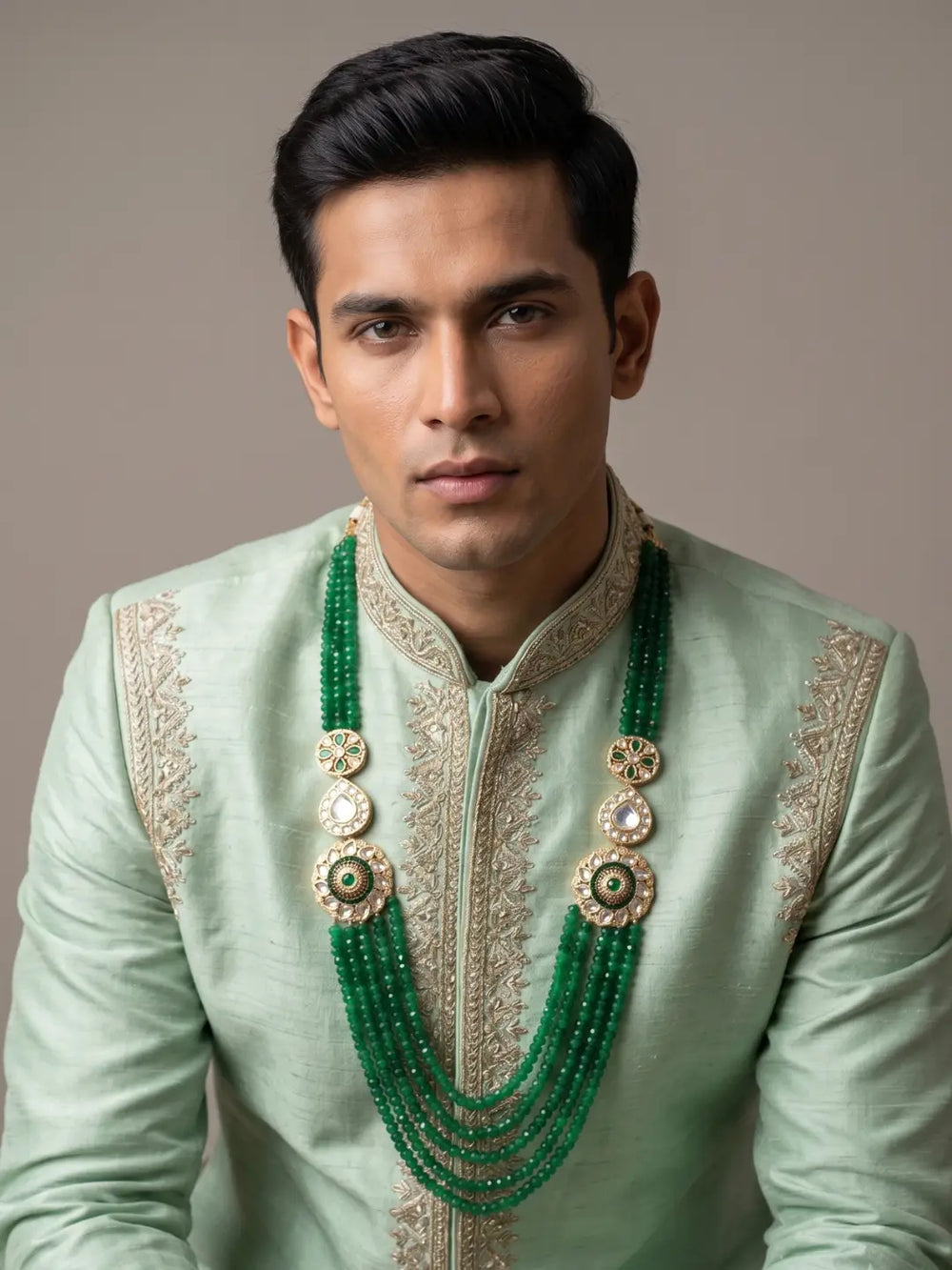 Green jade beaded dulha mala with ornate Kundan Polki brooches and gold-plated detailing, styled with a traditional groom's sherwani.