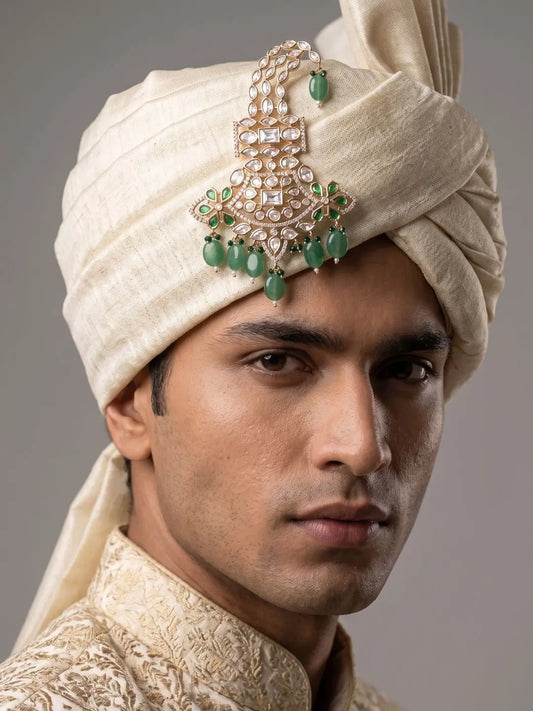 Groom wearing a green kundan polki kalgi pinned to a pagdi turban