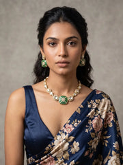 Green Kundan Polki necklace set with green enamel detailing, white stone accents and matching gold-tone earrings for festive styling.