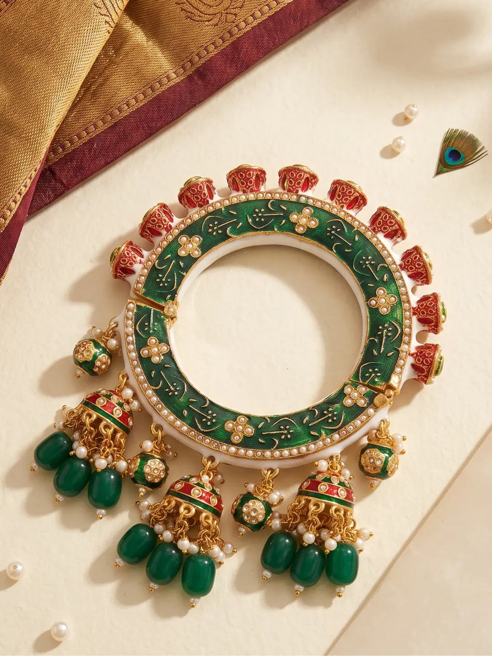 Green Meenakari Kundan Pacheli kada with floral motifs, pearl accents and jhumka details, styled as a statement bangle for ethnic outfits.