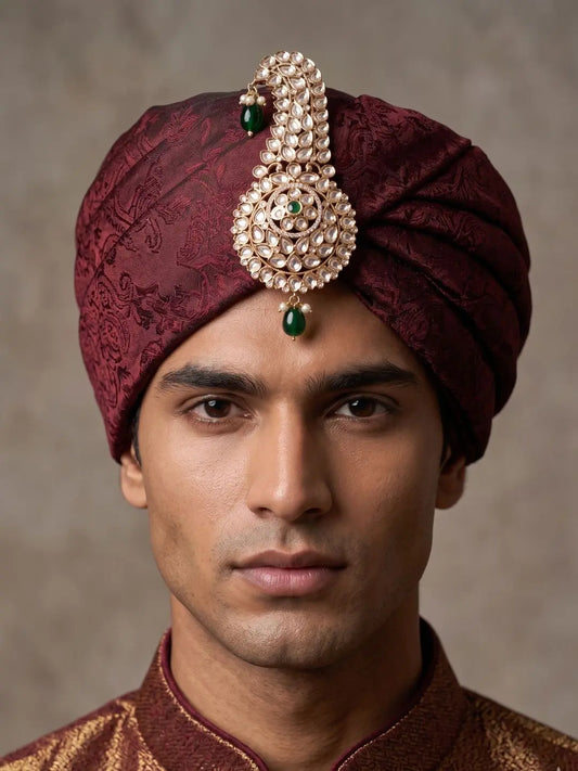 Groom wearing a green polki kundan kalangi pinned to a pagdi turban