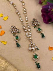 Flat lay of a green Polki pendant jewellery set featuring floral stonework, beaded drops and coordinating earrings.