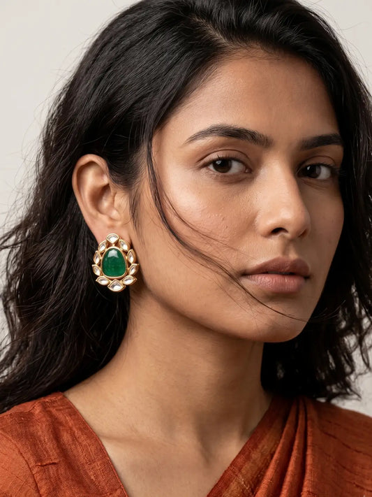Green Polki stud earrings with imitation emerald accents, ruby details, sparkling Kundan stones and ornate gold-toned floral design