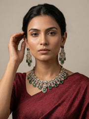 A women wearing Antique Green Emerald And American Diamond Wedding Jewellery Set on a red saree