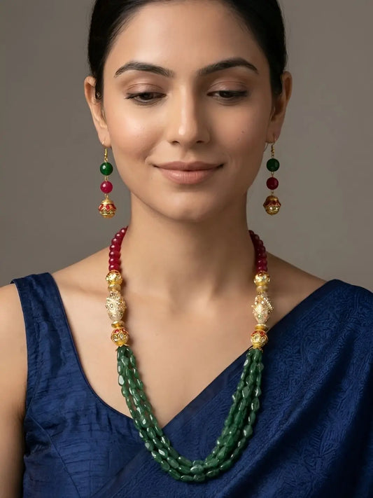 Woman wearing a long red and green beaded mala featuring jade beads, ornate gold-tone decorative beads and matching drop earrings for a traditional Indian ethnic look.