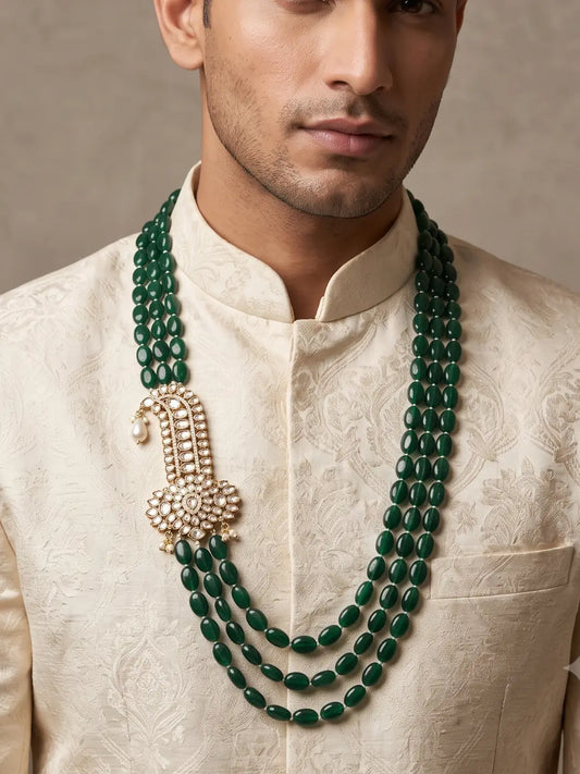 Deep green oval jade beads arranged in multiple layers with an ornate Kundan-inspired brooch and sparkling Polki accents
