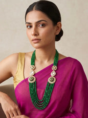 Long green jade beaded necklace featuring layered strands, floral Kundan-style brooches and white stone accents for Indian wedding outfits.