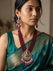 Maroon Ganesha temple necklace set featuring an ornate Ganpati pendant, antique-style detailing, layered jade beads and matching traditional earrings.