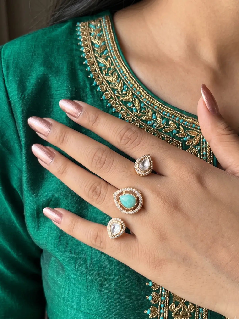 Mint green gold plated Kundan Polki dual finger ring with pear-shaped CZ details, styled as a statement accessory for bridal and festive looks.