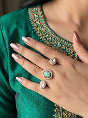 Mint green gold plated Kundan Polki dual finger ring with pear-shaped CZ details, styled as a statement accessory for bridal and festive looks.