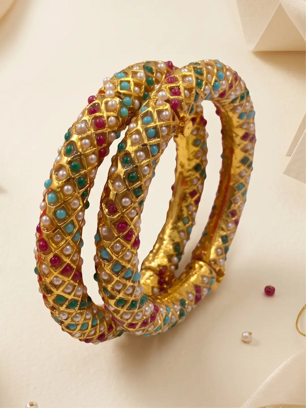 Multicolor gold plated Indian bangles with pearl and imitation stone details, styled to complement sarees, lehengas and traditional outfits.