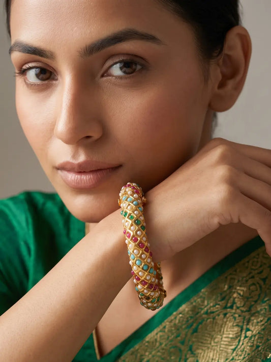 Multicolor gold plated Jadau bangles with pearl and stone detailing in pink, green and blue tones for festive and wedding outfits.