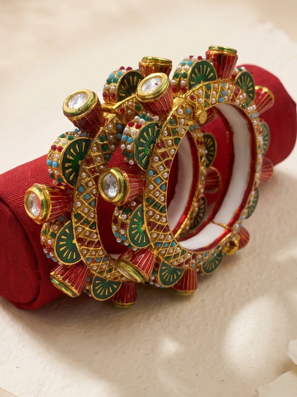 Multicolour Meenakari Kundan Gokhru kada bangles with red, green and ivory accents, pearl-style detailing and gold plating for festive looks.