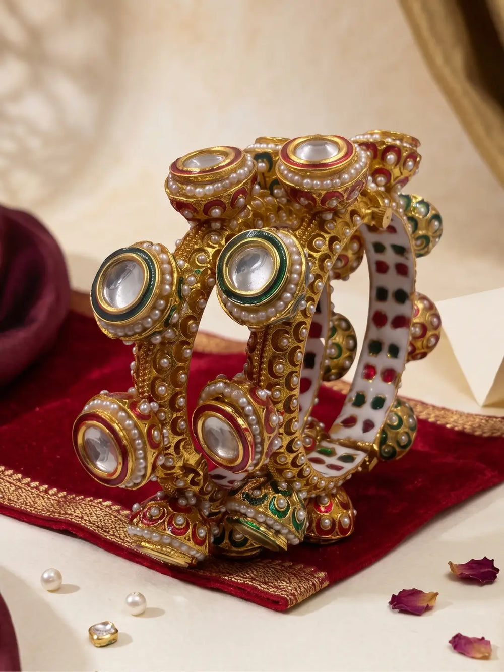 Multicolour Meenakari Kundan Gokhru kada bangles with red and green enamel, pearl accents and gold plating for bridal and festive outfits.