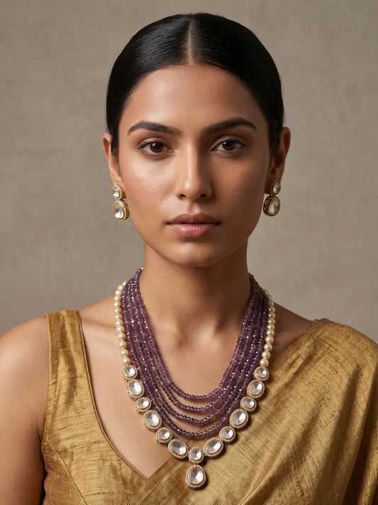 Natural amethyst beaded necklace with pearl accents, Kundan-style detailing and matching gold-tone drop earrings.