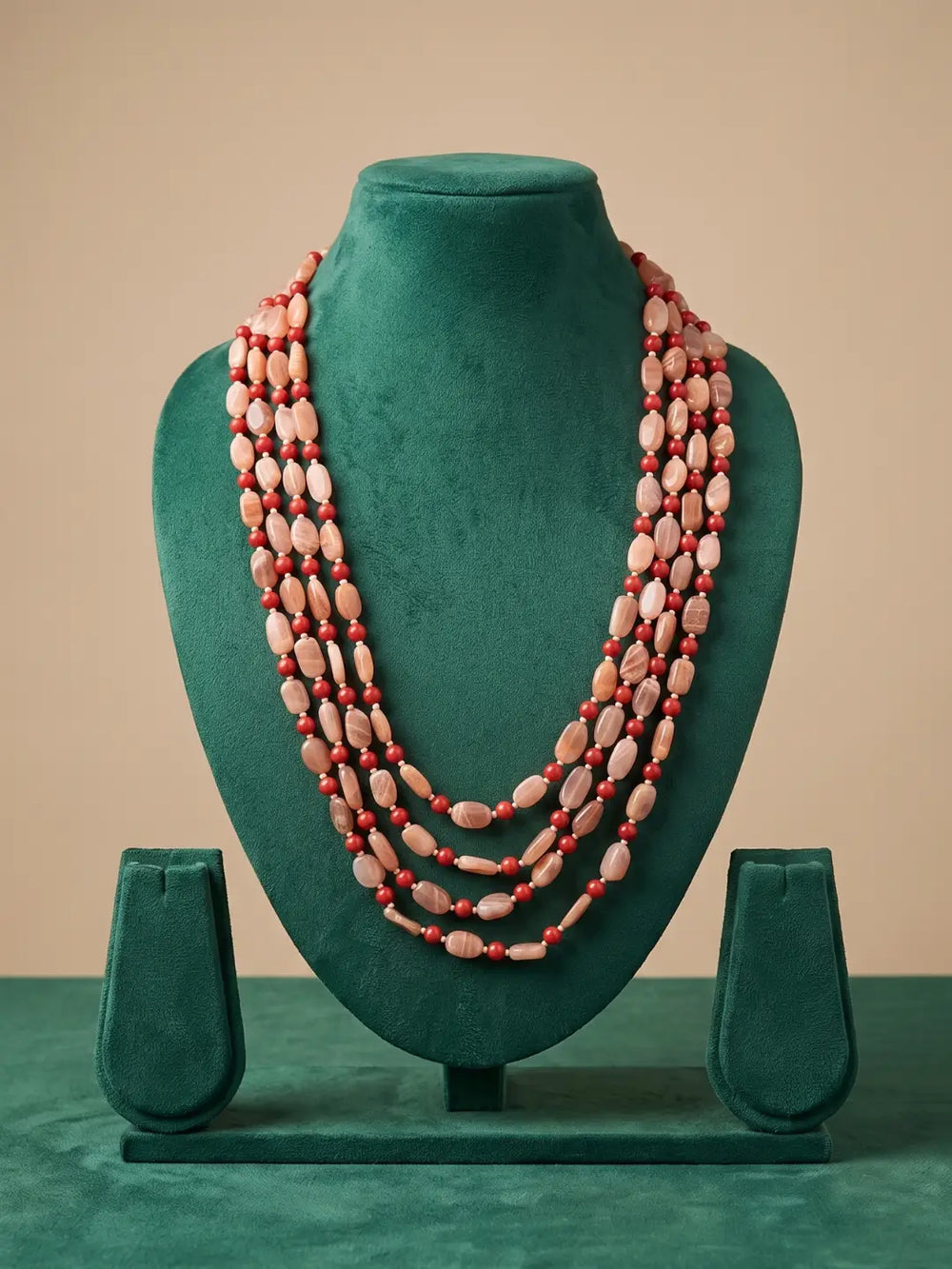 Red coral and moonstone layered mala with multiple strands, styled as a statement beaded necklace for sarees, lehengas and Indo-Western outfits.