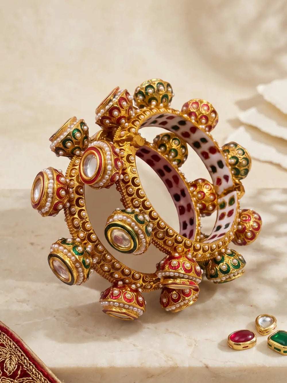 Red and green Meenakari Kundan Gokhru kada bangles featuring white pearl detailing, Kundan stones and a gold-plated base for wedding styling.