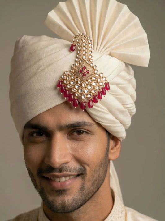 Groom wearing a red Meenakari Polki safa kalgi styled on a traditional wedding turban