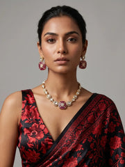Ruby pink Kundan Polki necklace set with a red and green enamel-inspired centre, white stone accents and matching gold-tone earrings.