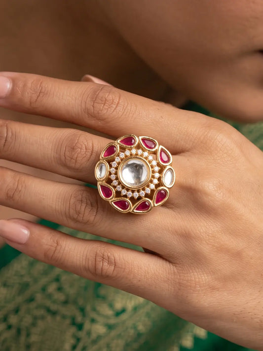 Ruby Kundan style statement ring featuring a round Polki centre, white CZ accents, ruby-red petal motifs and a warm gold plated finish