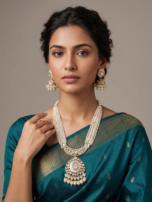 Multi-strand pearl Kundan necklace with dramatic pendant and matching jhumkas, creating an elegant traditional wedding look.