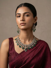 Woman wearing a maroon saree with Antique Green Emerald and American Diamond Wedding Jewellery Set against a neutral background