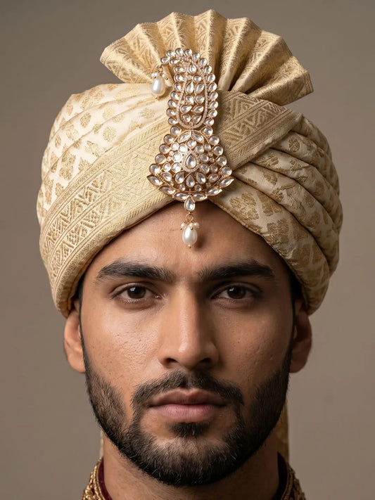 Groom wearing a white kundan polki kalangi pinned to an ivory safa for the pheras