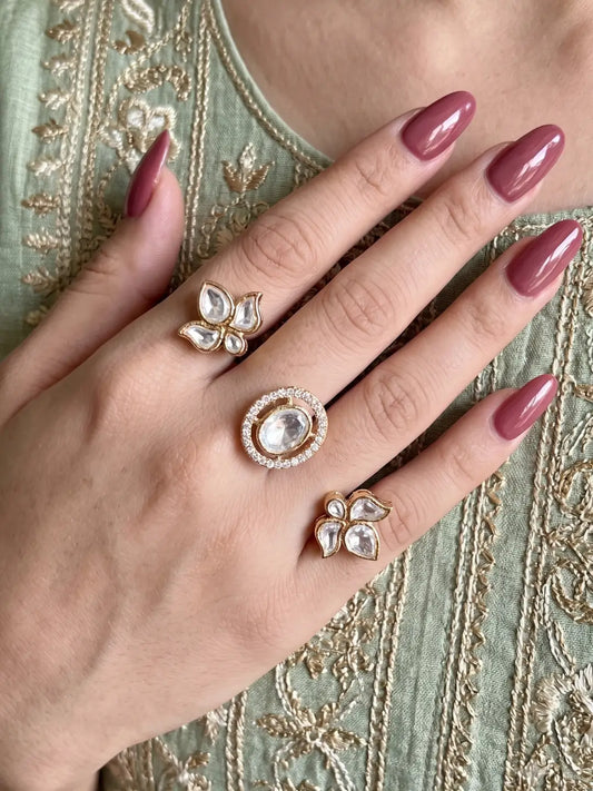 White Polki Kundan dual finger ring featuring two gold-tone bands, three floral clusters, pear-shaped stones and CZ accents for bridal and festive wear