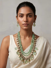 a women wearing a Designer Beaded Green Stone & Uncut Kundan Layered Necklace Set on a white saree| Wedding & Festive Wear