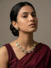 Woman wearing a maroon saree with a floral design, single-line polki necklace set against a neutral background