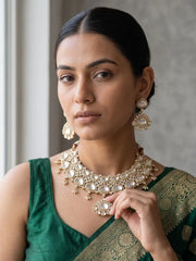 a women wearing and Elegant Gold Plated Wedding And Bridal Wear Kundan Necklace Set on a green silk saree