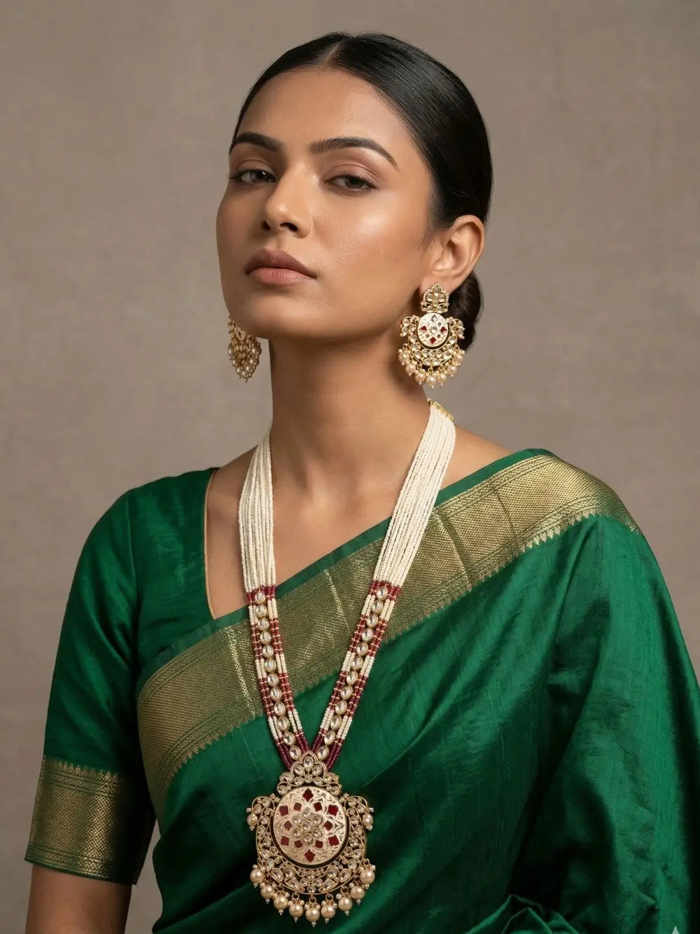 Woman wearing a traditional long pearls-beaded Kundan Necklace Set With Red Enamel on a green saree