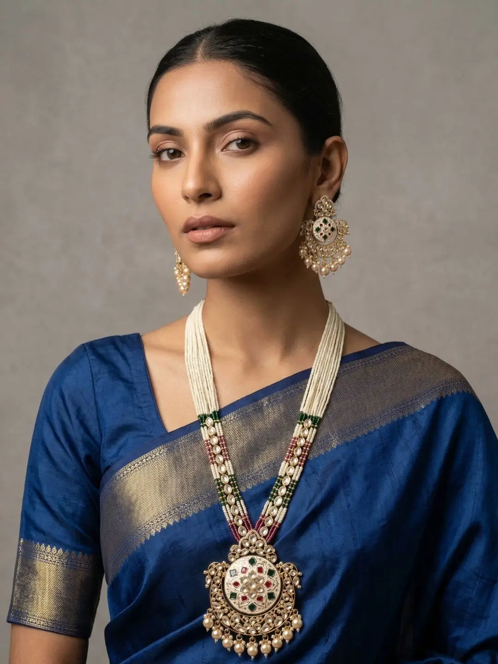 A women wearing a Traditional Long Pearls Beaded Kundan Necklace Set With red and greenn Enamel on a blue saree