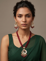 A women wearing a Designer Mother Of Pearl And Kundan Pendant Necklace Set beaded with red jade beads.