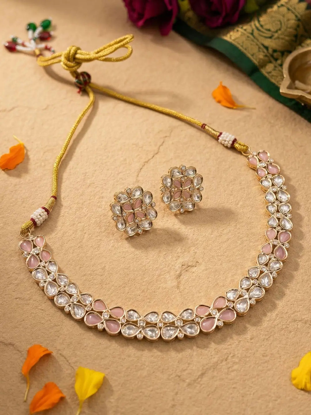 Pink Kundan Necklace and earrings set on a beige background with decorative elements